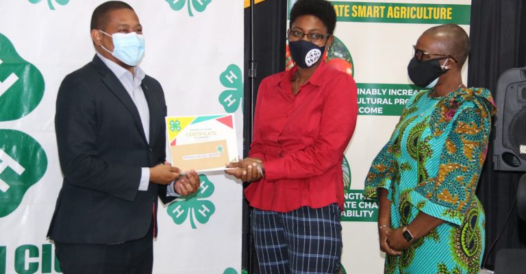 Minister of Agriculture and Fisheries, Hon. Floyd Green (left) presents a certificate of award to winner of the Jamaica 4-H Clubs Backyard Family Garden Challenge, Shaneka Wallace-Graham from St. James, at the virtual award ceremony on Thursday (February 25). At right is Resident Representative, United Nations Development Programme (UNDP) Multi-Country Office in Jamaica, Denise Antonio. Mrs. Wallace-Graham received a cash prize of $60,000, seedlings, and gardening tools.